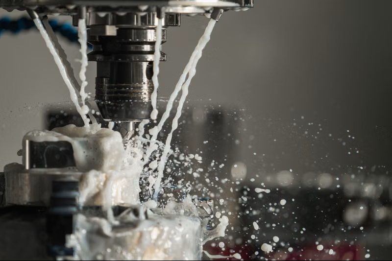 Macchina CNC con refrigerante durante la lavorazione